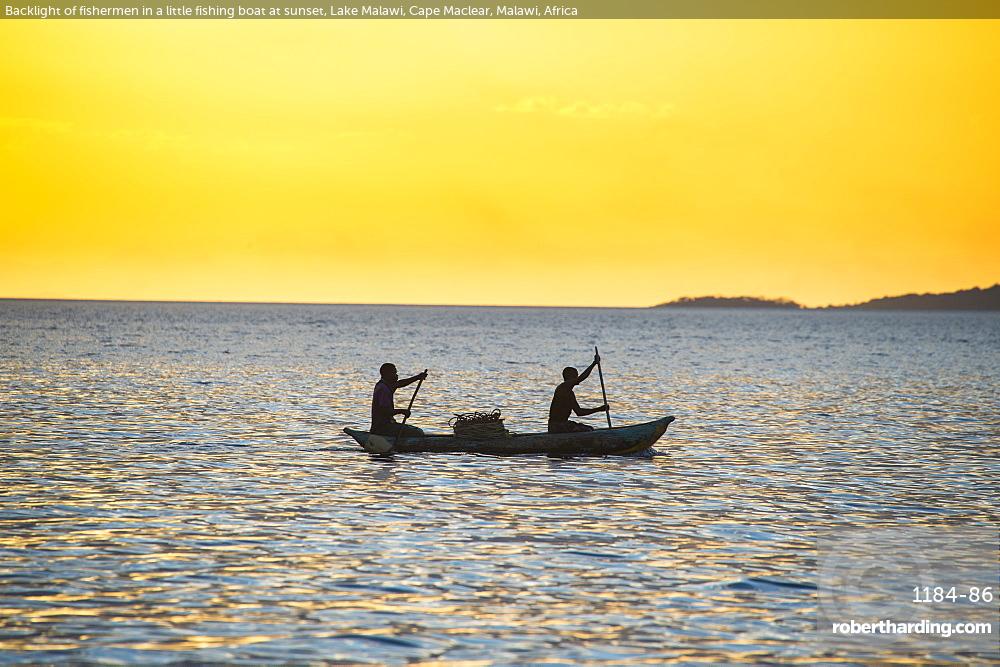 Backlight of fishermen in a little fishing boat at sunset, Lake Malawi, Cape Maclear, Malawi, Africa