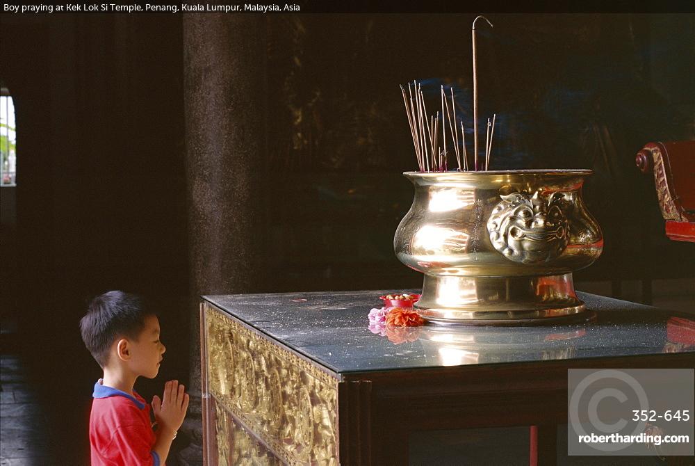 Boy praying at Kek Lok Si Temple, Penang, Kuala Lumpur, Malaysia, Asia